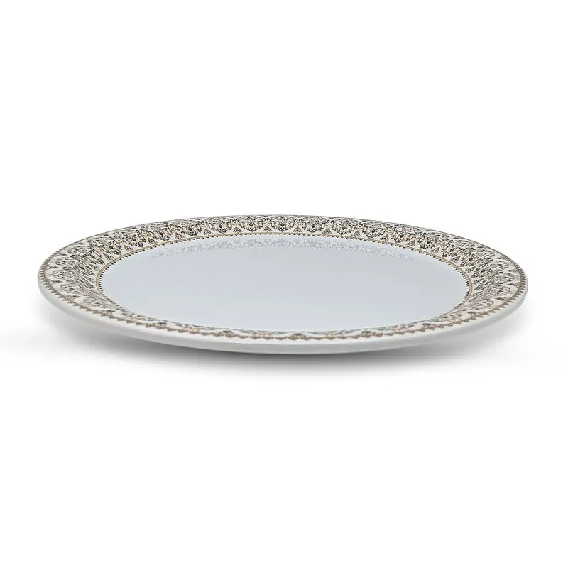 Side view showing the shallow profile and decorative border of a white quarter plate.