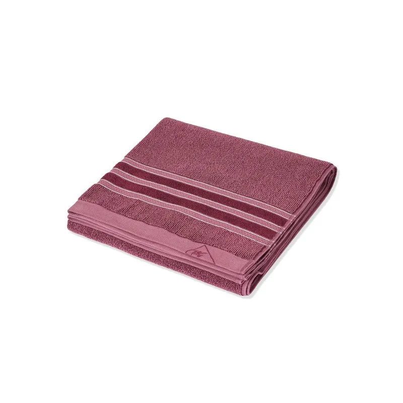 Folded maroon bath towel showing its striped decorative border