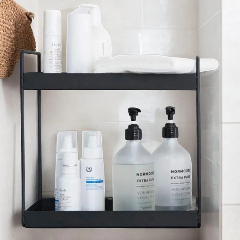 Black two-tier rack holding bottles and toiletries against a tiled wall