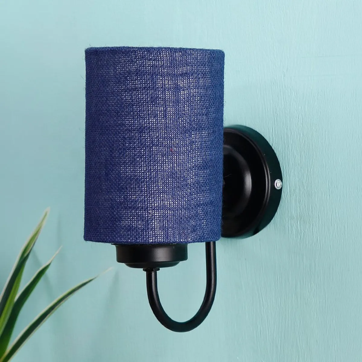 Blue jute wall lamp shown unlit against a blue wall