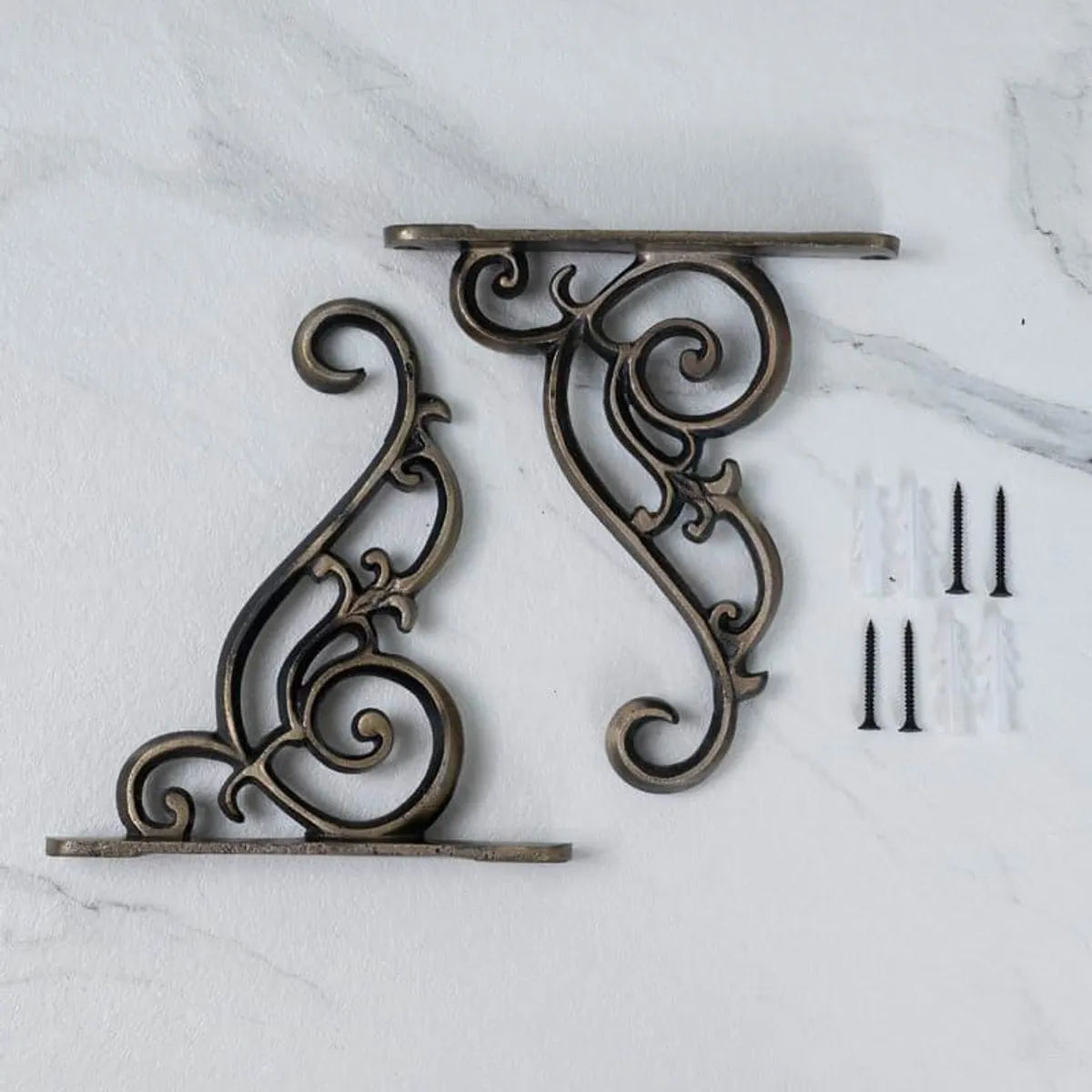 Pair of ornate copper wall brackets displayed with mounting hardware