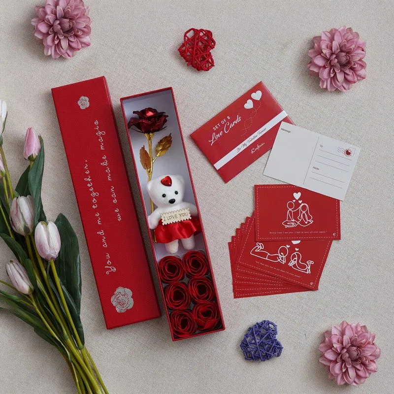 Red rectangular gift box with teddy, rose and love cards arranged beside it