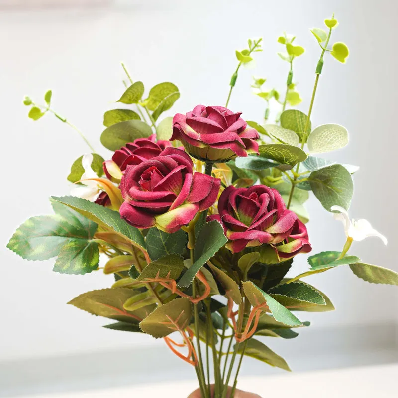 Close-up of deep pink artificial roses with green leaves
