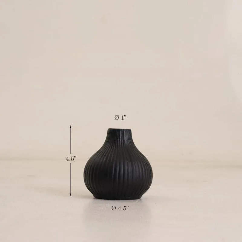 Black ribbed urn vase on a light surface