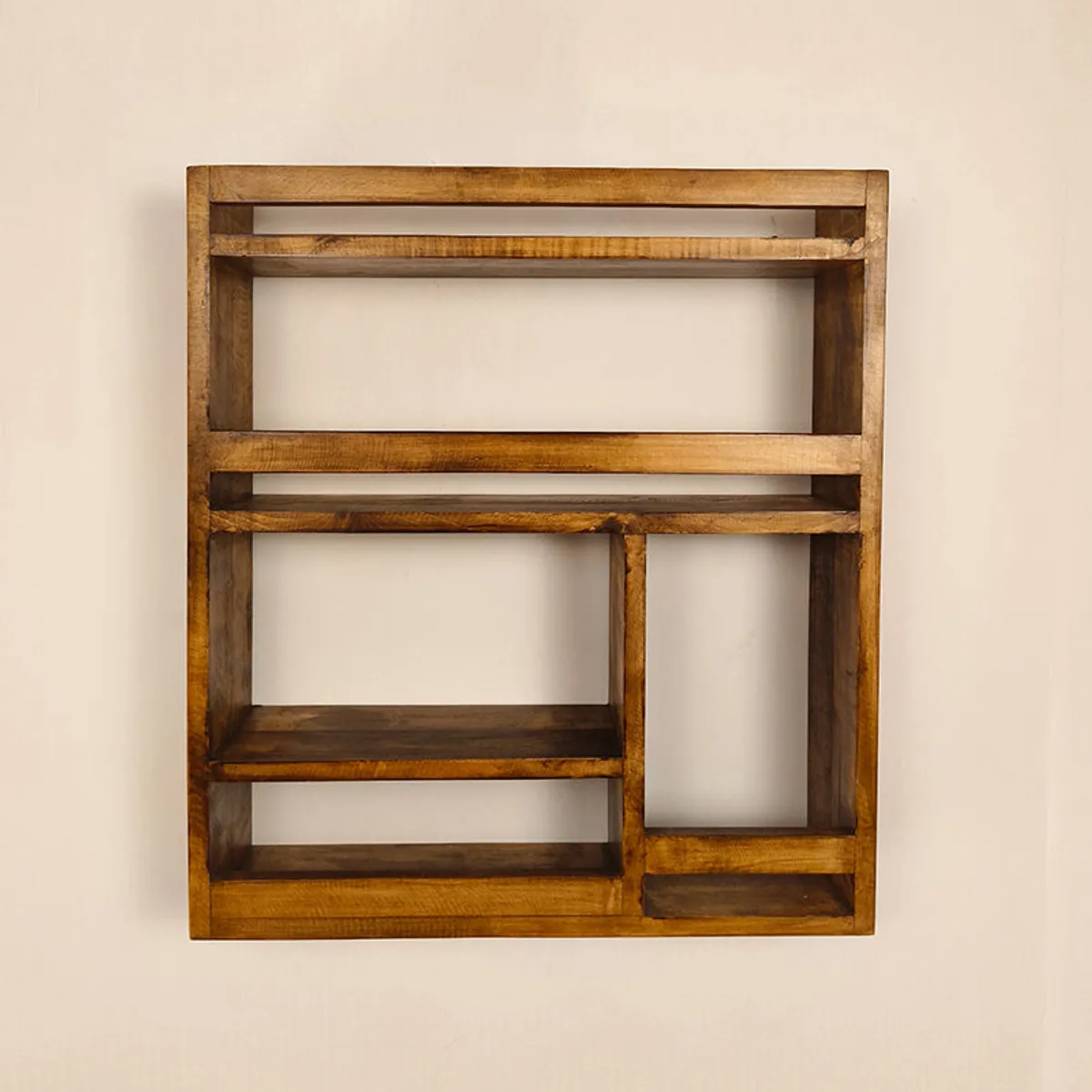 Back view of a rectangular brown wooden rack with varied open compartments