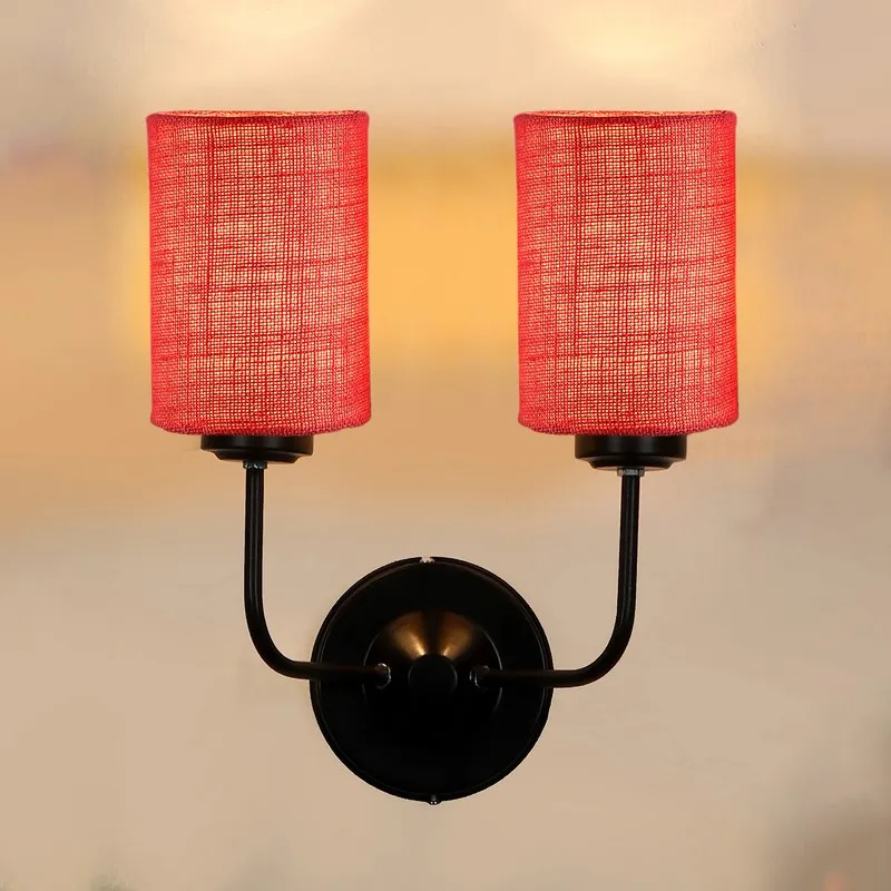 Front close-up of pink jute twin wall lamp with black iron base