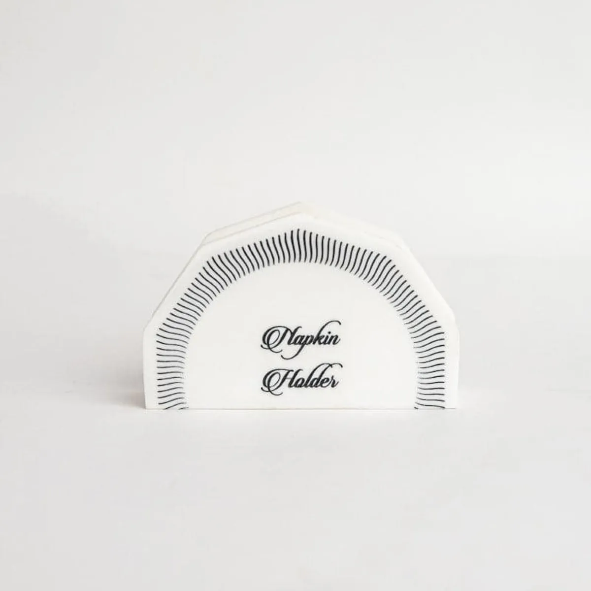 Front view of a white marble napkin holder with black decorative lines.