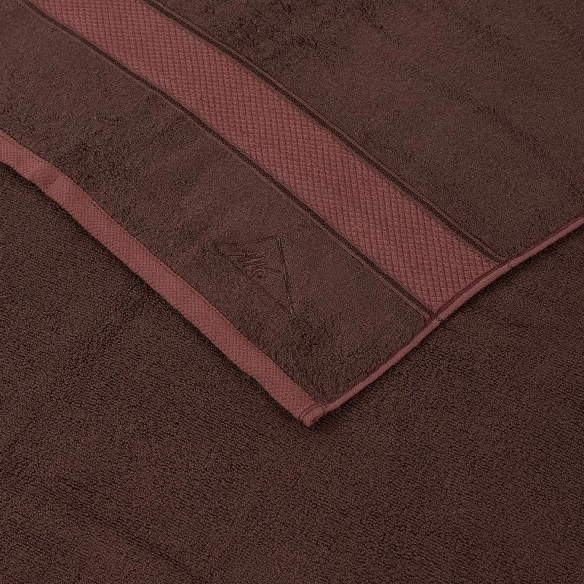 Close-up view of the towel's coffee brown textured surface and contrasting border.