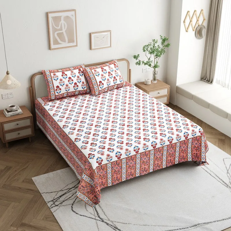 Floral maroon, blue and white bedsheet styled on a bed with matching pillow covers