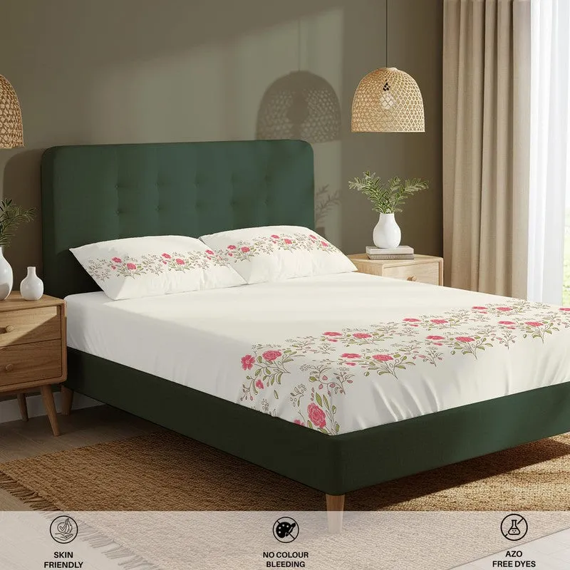 Angled view of white floral bedsheet set styled on a green bed
