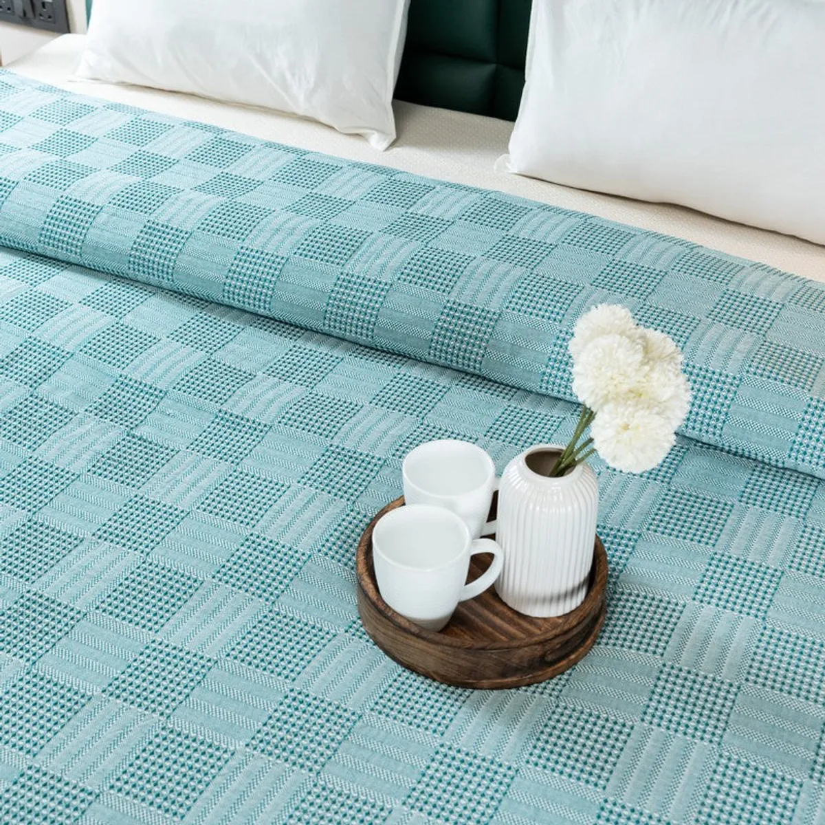 Textured green bedsheet shown with a folded top edge and bedside tray