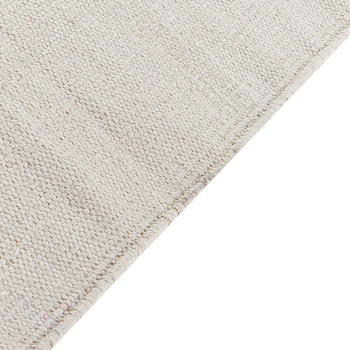 Close-up of the cream textured rug surface and finished edge