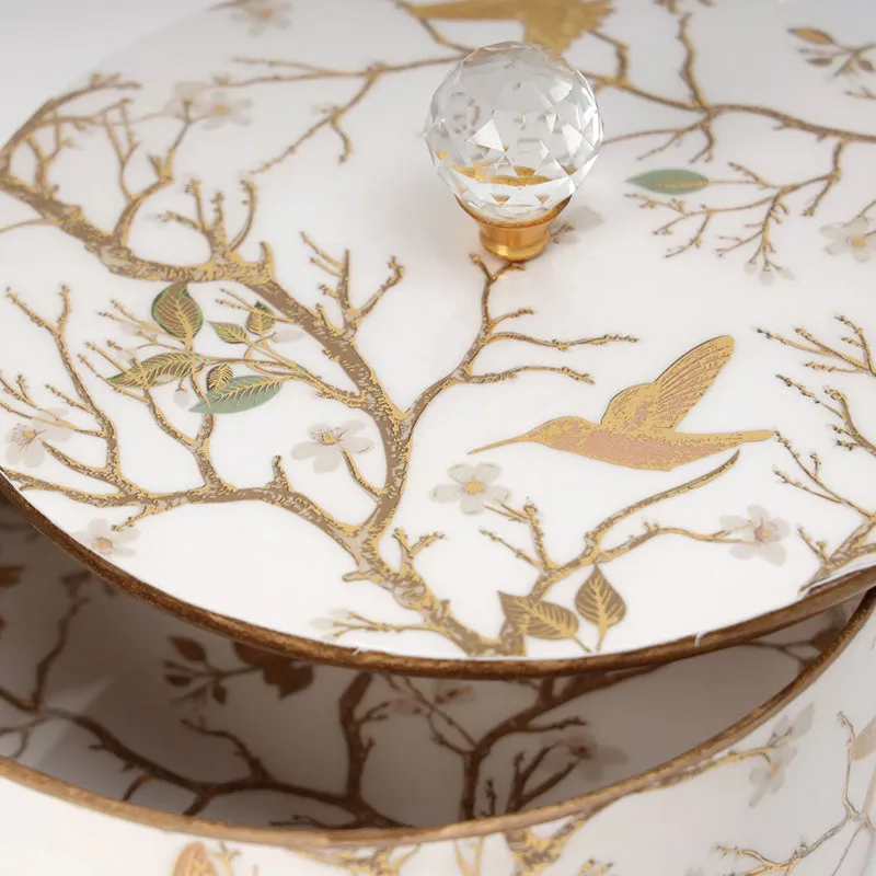 Close-up of crystal knob and gold bird-and-branch decoration on the box lid