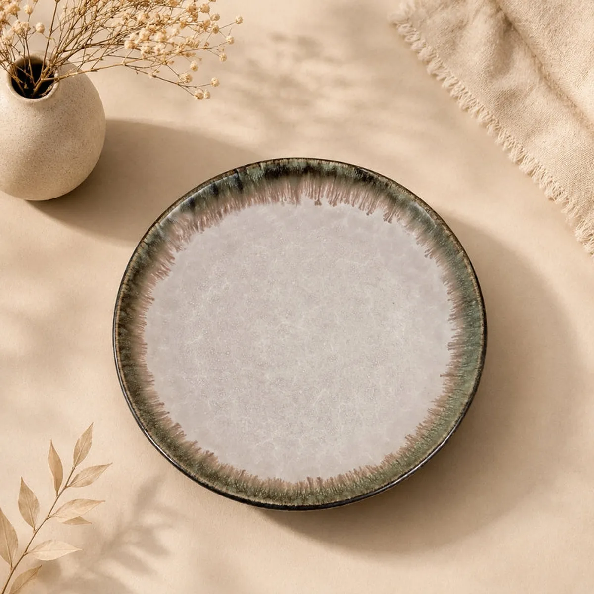 Round pink ceramic plate shown from above with a dark textured rim