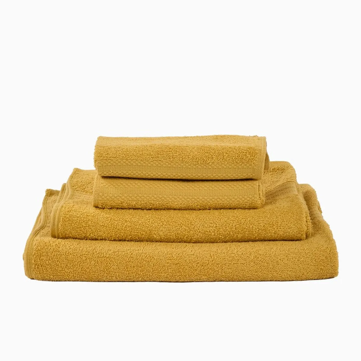 Folded yellow towels stacked neatly against a plain white background.