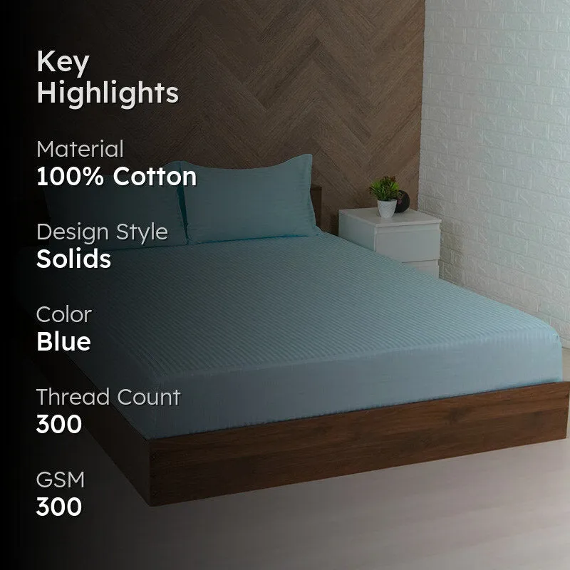 Light blue fitted bedsheet with subtle stripes shown on a wooden bed