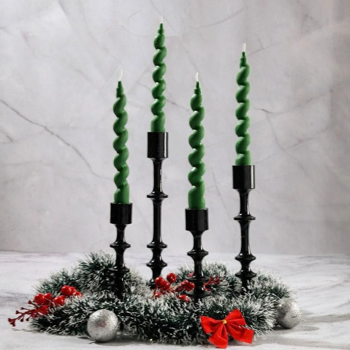 Unlit green spiral taper candles in black holders