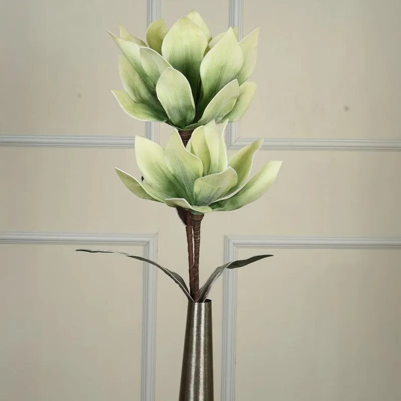 Close-up of two pale green artificial blooms and leaves on a brown stem