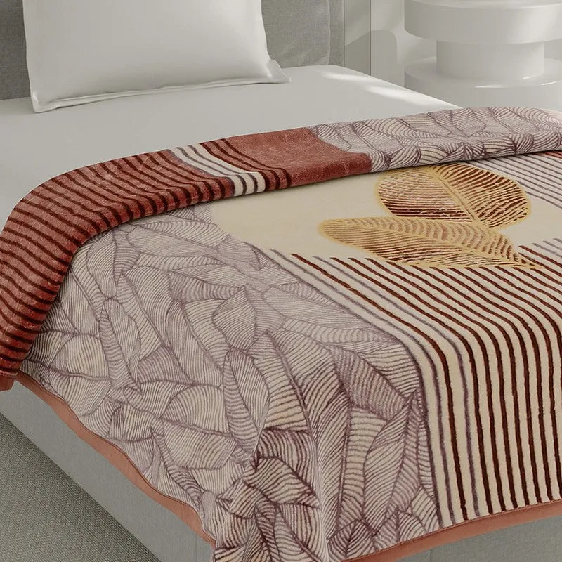 Close-up of the blanket showing leaf motifs, stripes and a soft-looking surface