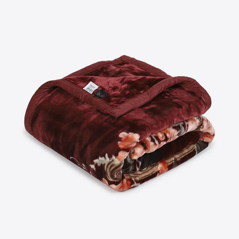 Folded red floral blanket showing its soft-looking surface
