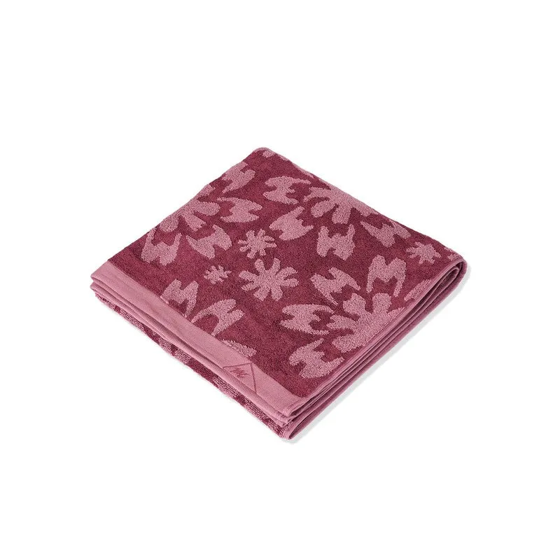 Folded maroon floral bath towel shown against a plain white background.