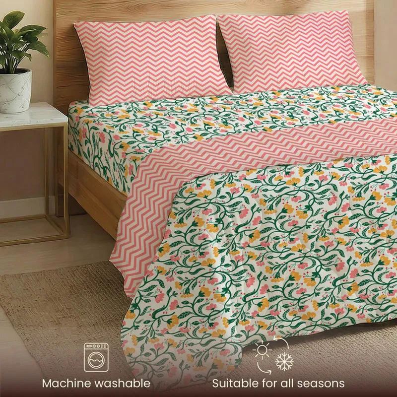 Angled view of floral bedding set with pink patterned reverse side