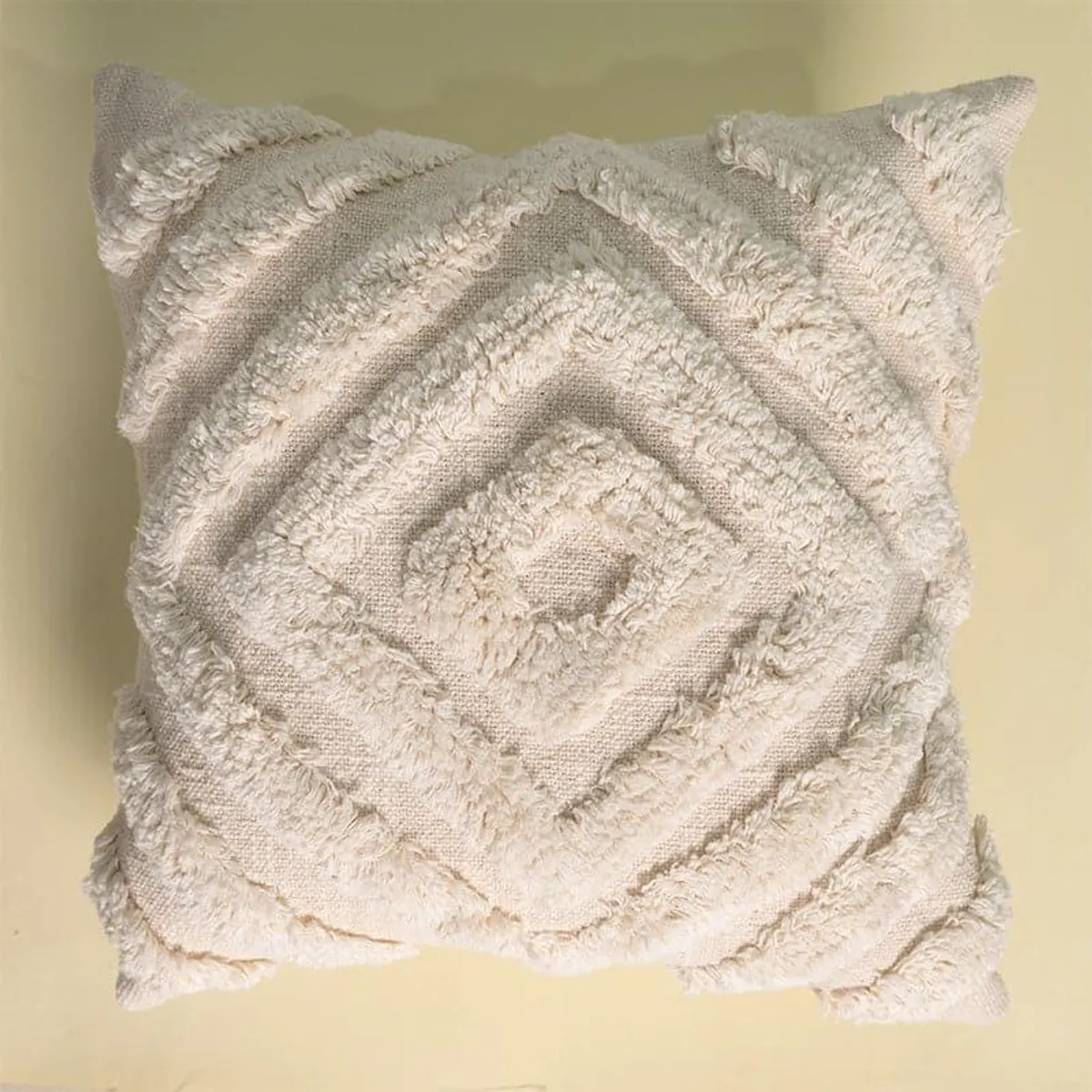 Close view of an ivory cushion cover with concentric diamond texture