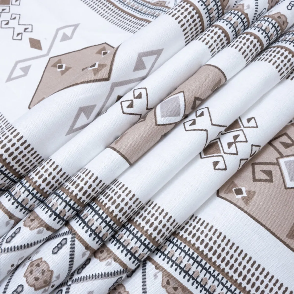 Folded section of the bedsheet showing the white and brown geometric pattern in detail.