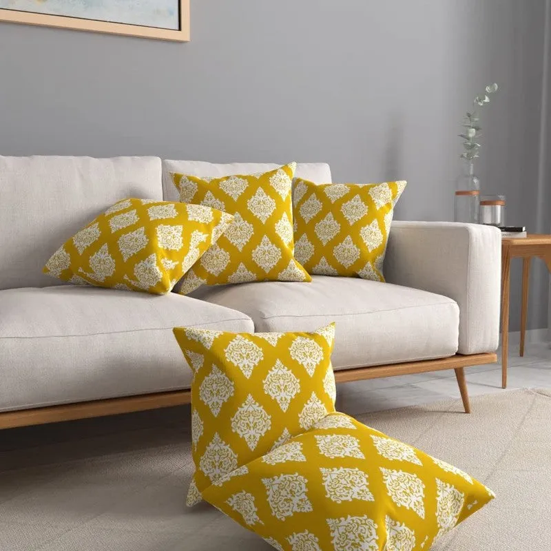 Set of yellow patterned cushion covers arranged on and in front of a sofa