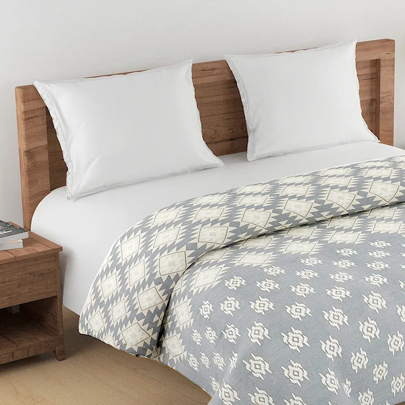 Close view of the grey and white comforter with geometric and floral motifs