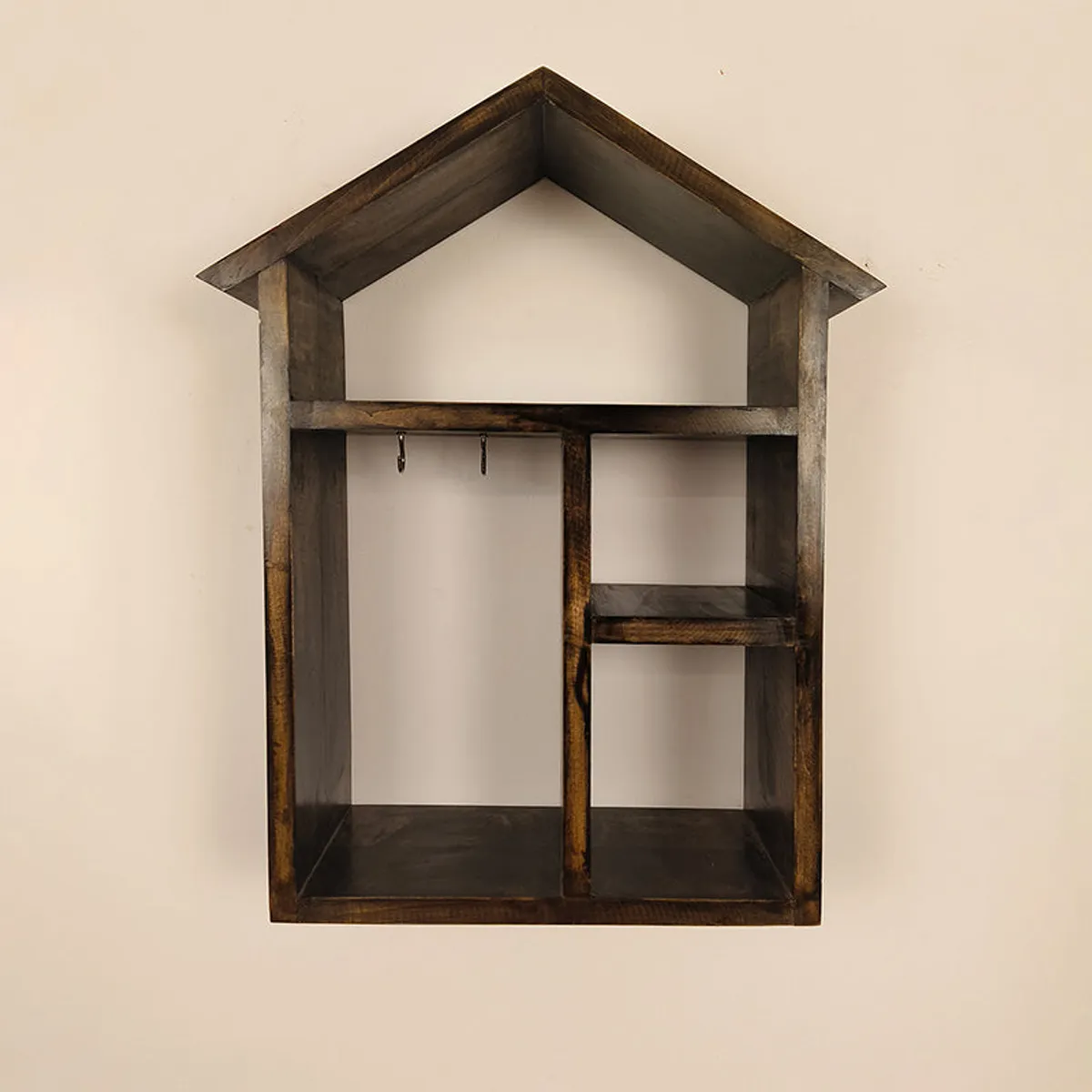 Empty brown house-shaped wall shelf showing compartments and key hooks