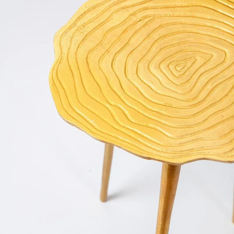 Close-up of gold table top with organic ring-like texture and tapered legs