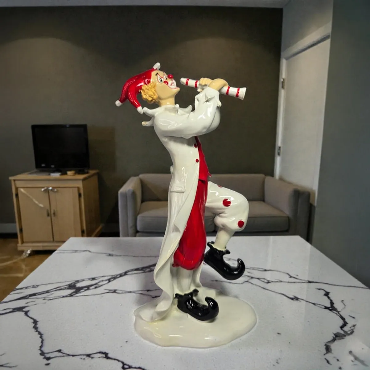 Side view of red and white clown figurine showpiece on a tabletop