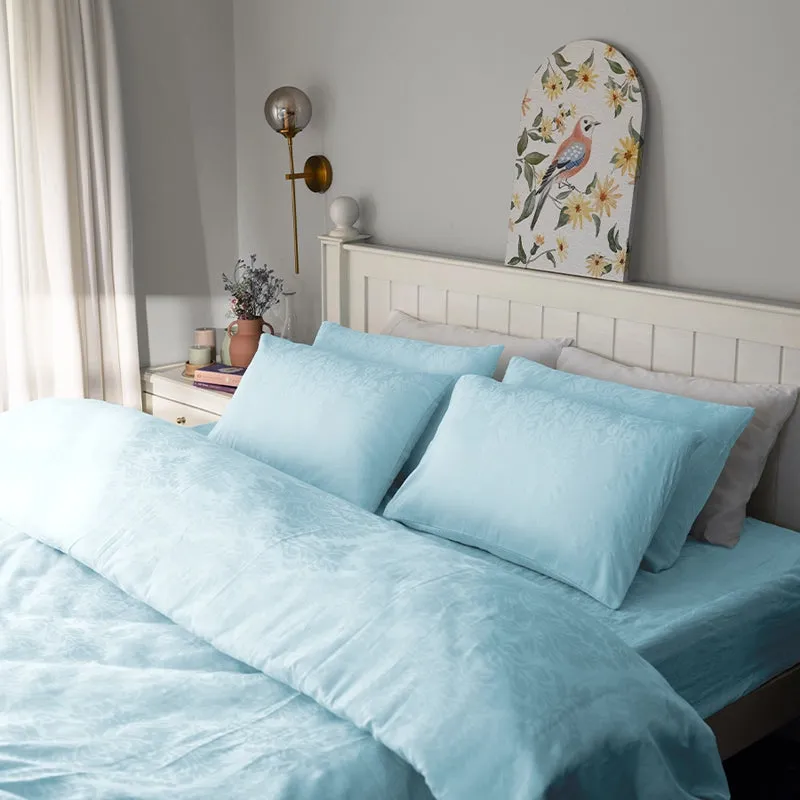 Pale blue bedding set styled on a bed with matching pillow covers