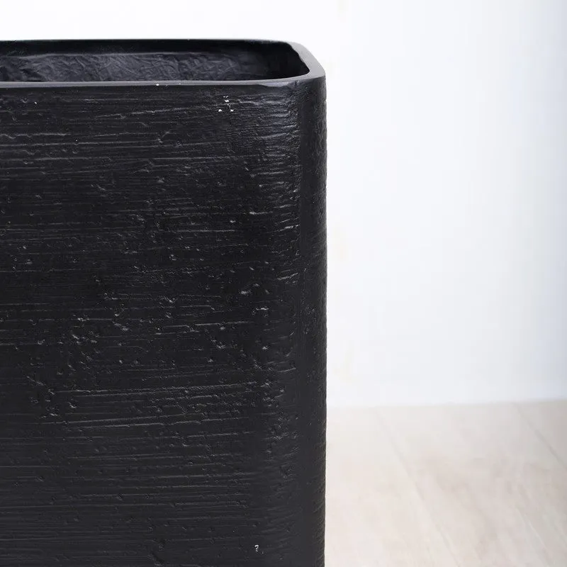 Close-up of the planter's black textured matte surface and rounded edge