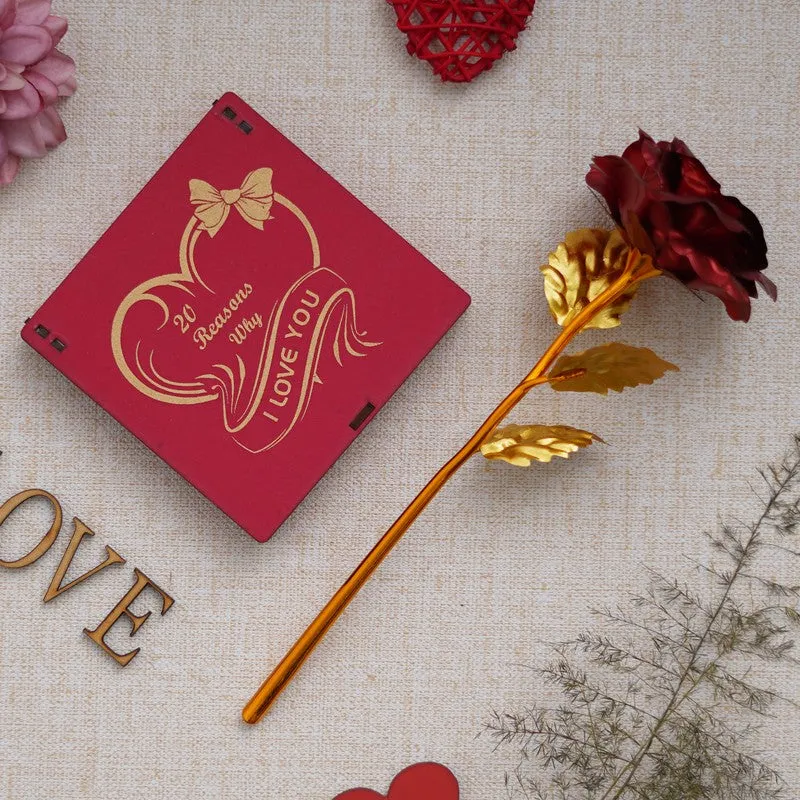 Red gift box with gold print and metallic rose on a beige backdrop