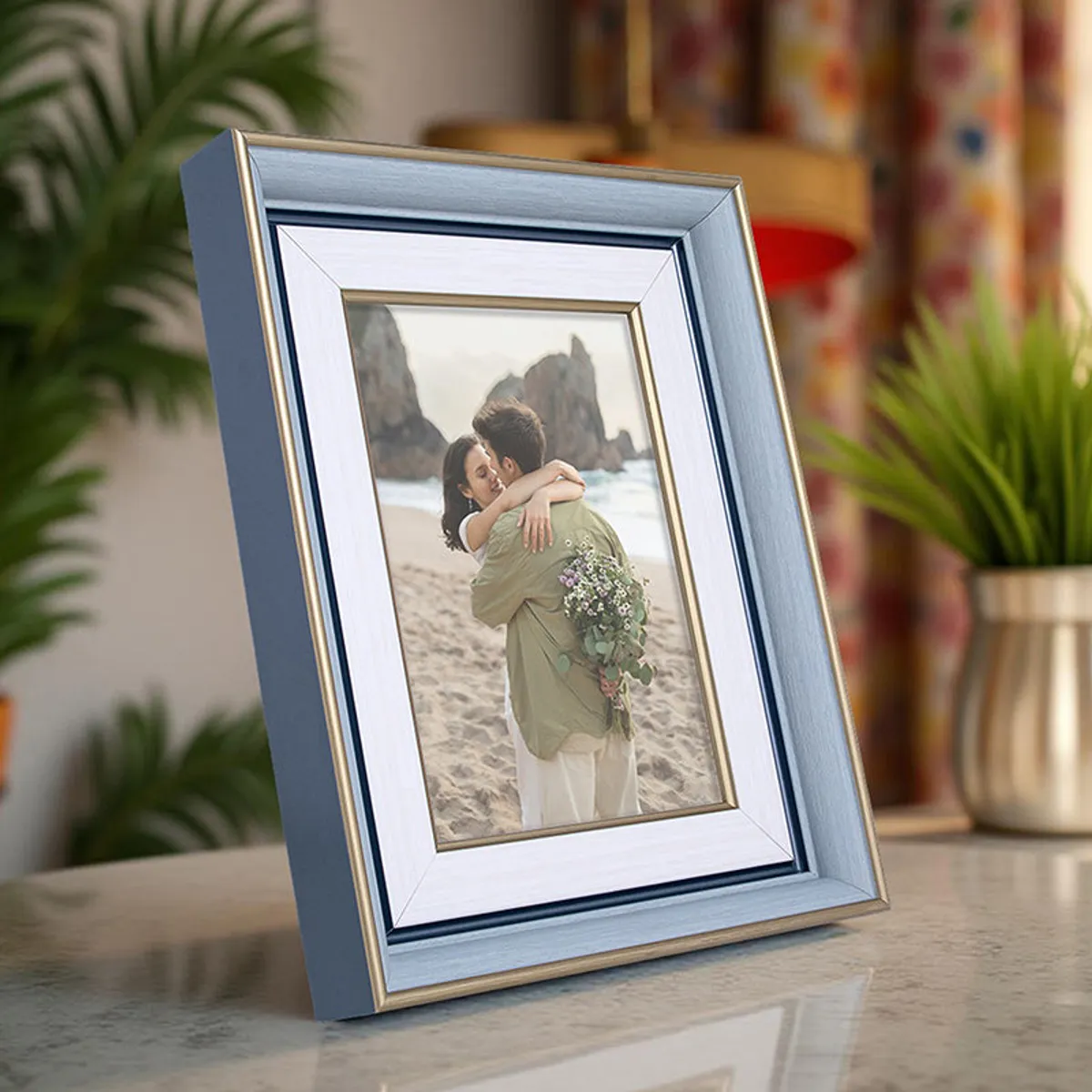 Blue and white tabletop photo frame styled against a colourful room backdrop