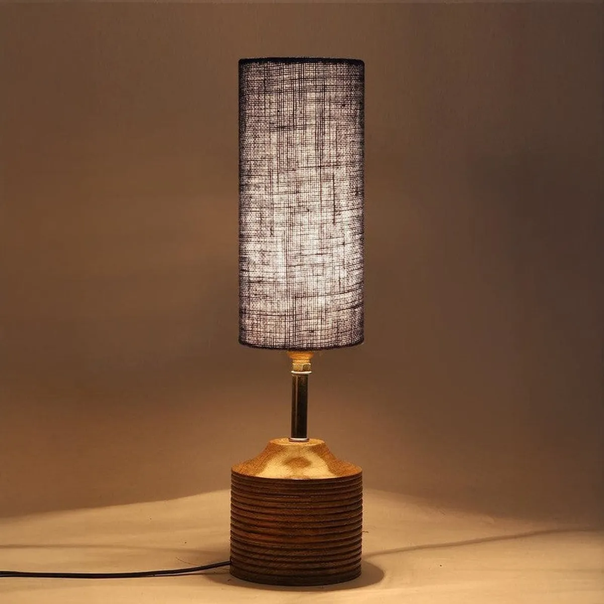 Table lamp switched on with blue shade and brown textured base