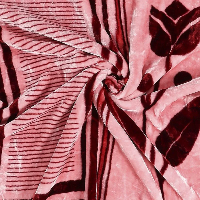 Close-up view of the blanket's soft-looking maroon and pink pattern