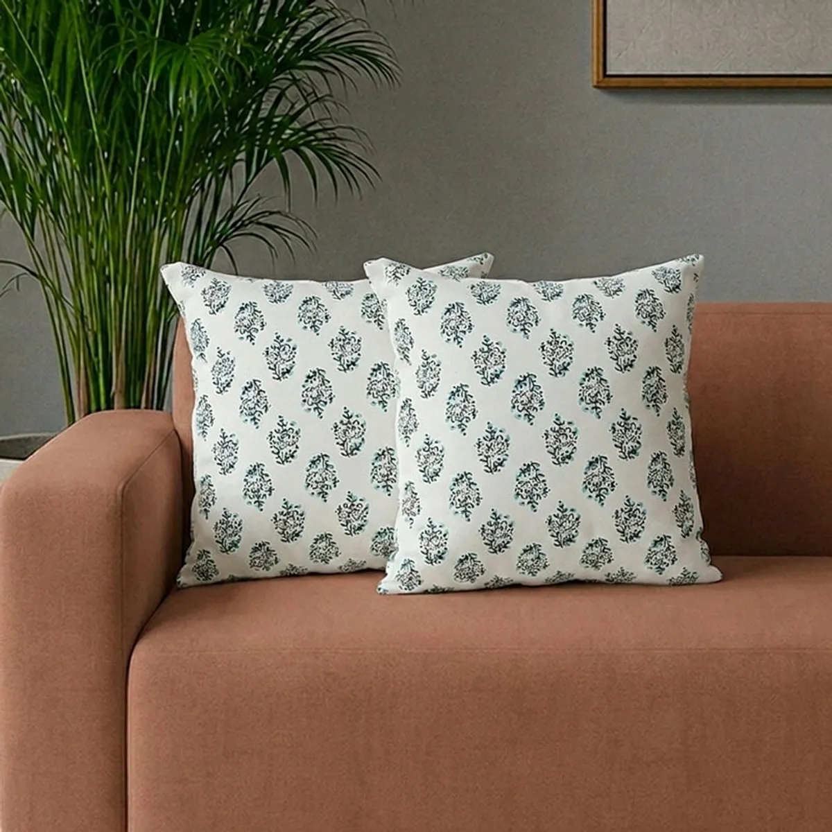 Two floral cushion covers styled on a brown sofa