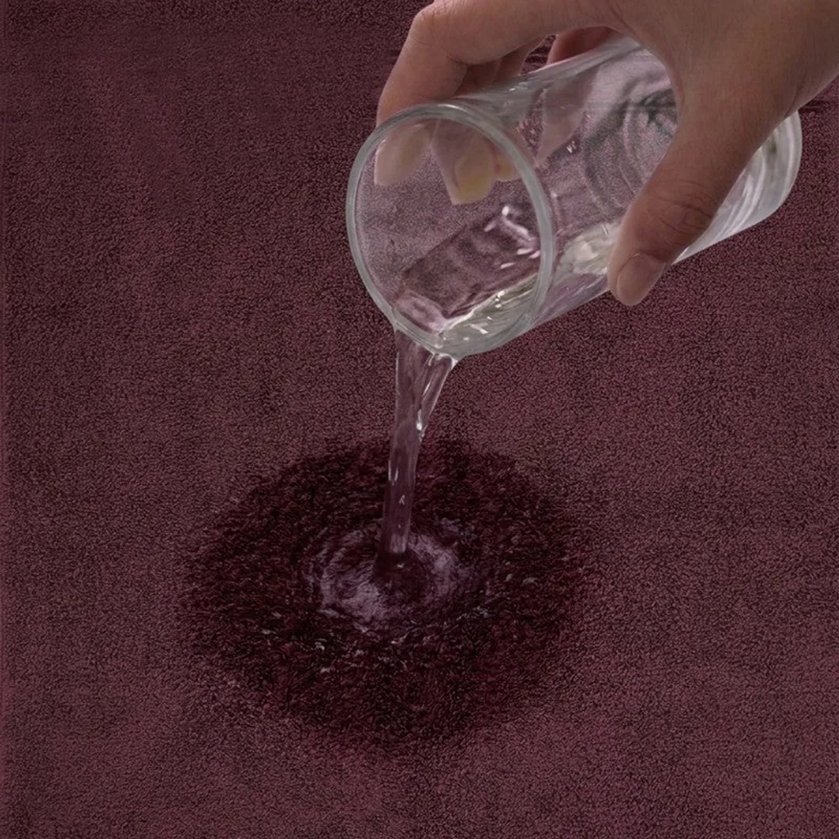 Close-up of water being absorbed by the textured purple towel
