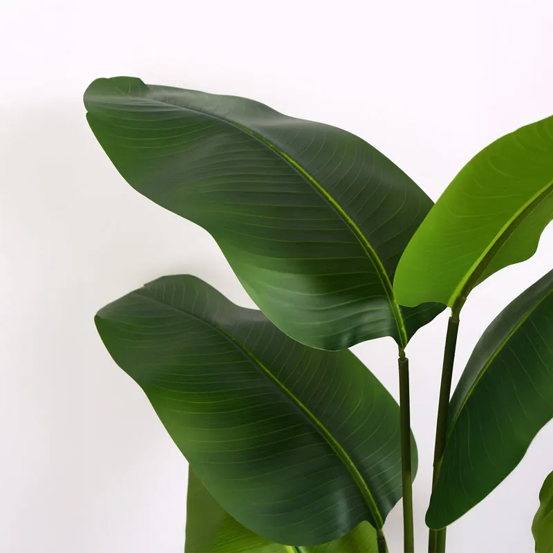 Close-up of broad green artificial banana leaves with visible central veins