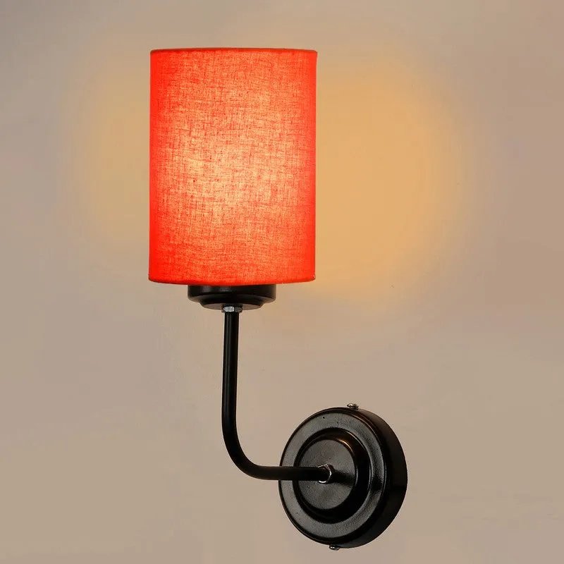 Close-up of orange shade wall lamp with black round wall mount