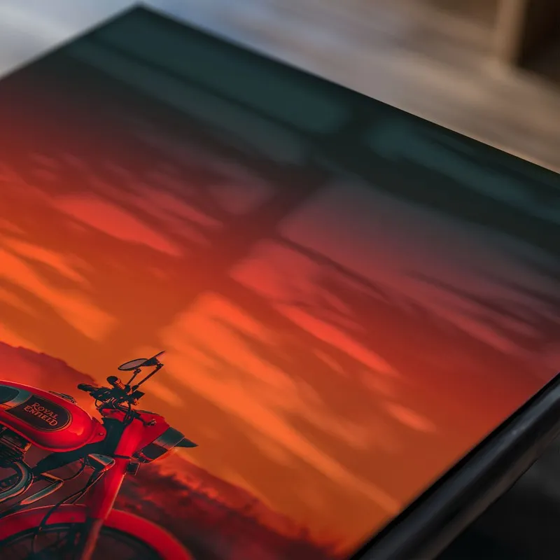 Close-up of a motorcycle poster against a vivid red-orange sky