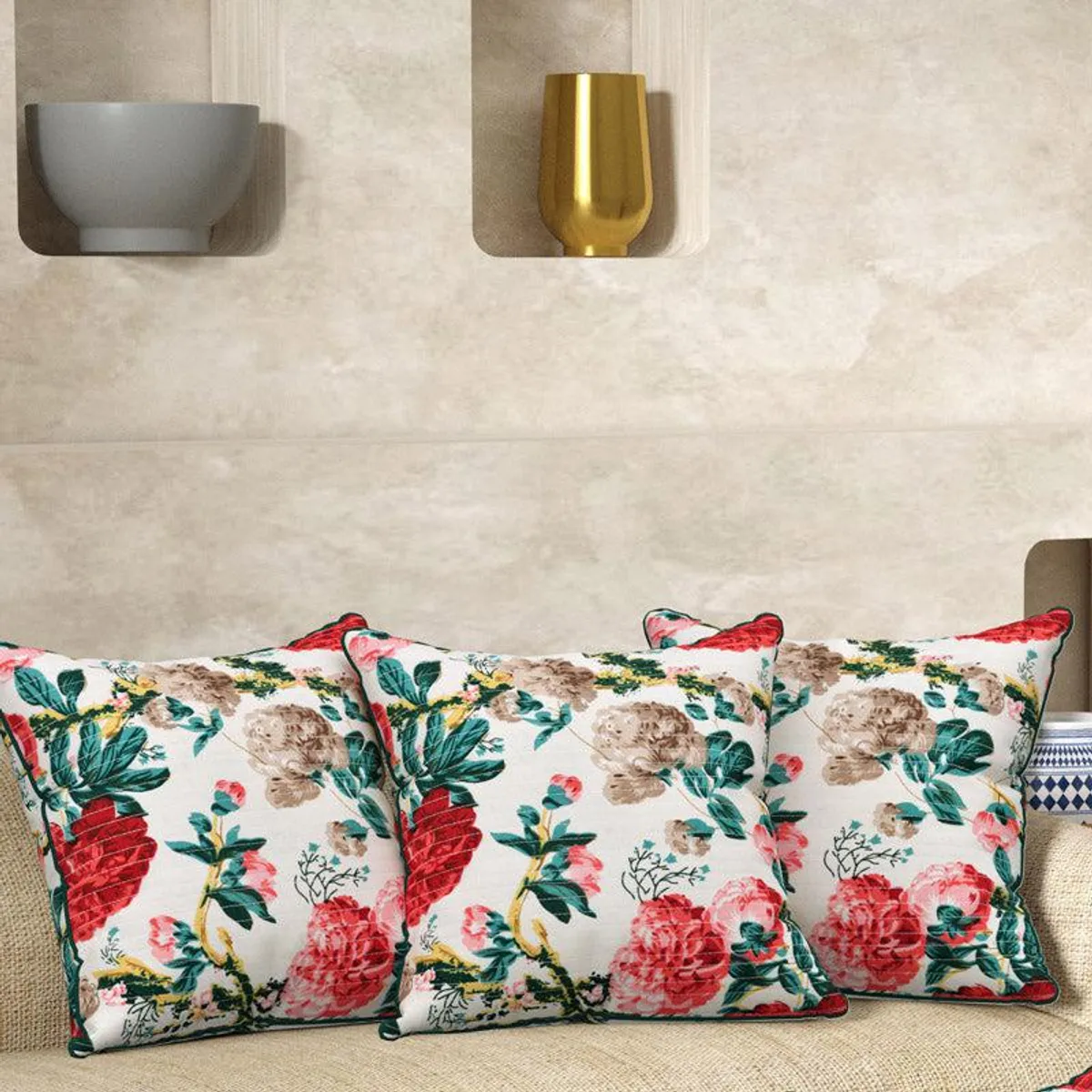 Three floral cushion covers arranged across a neutral sofa