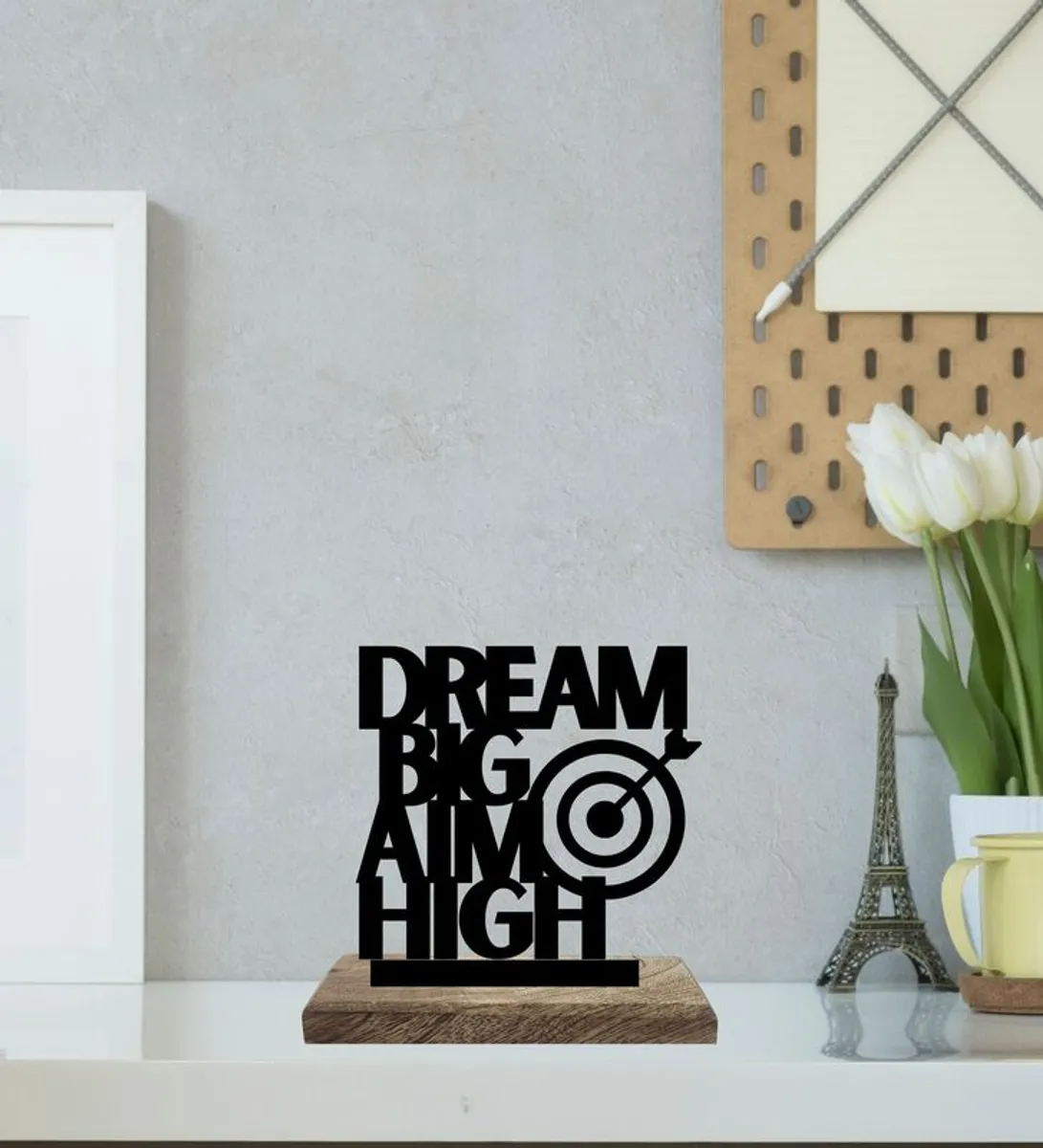 Black typography showpiece with target motif on a wooden base on a shelf.