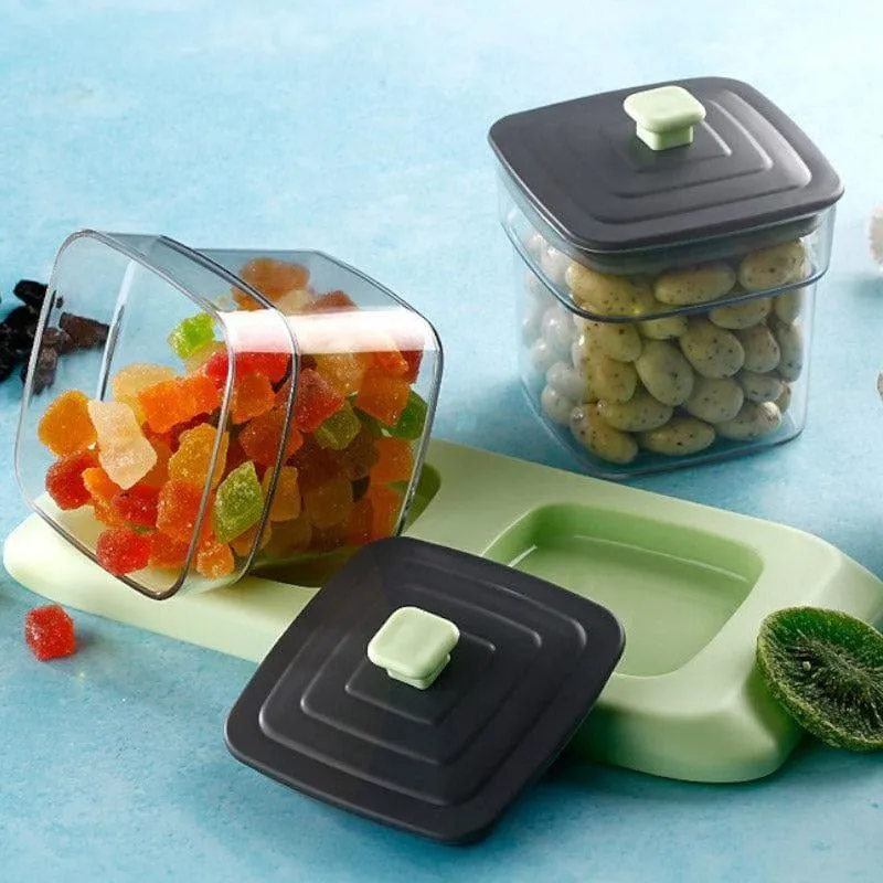 Close view of transparent containers, black lids and mint tray with snacks.