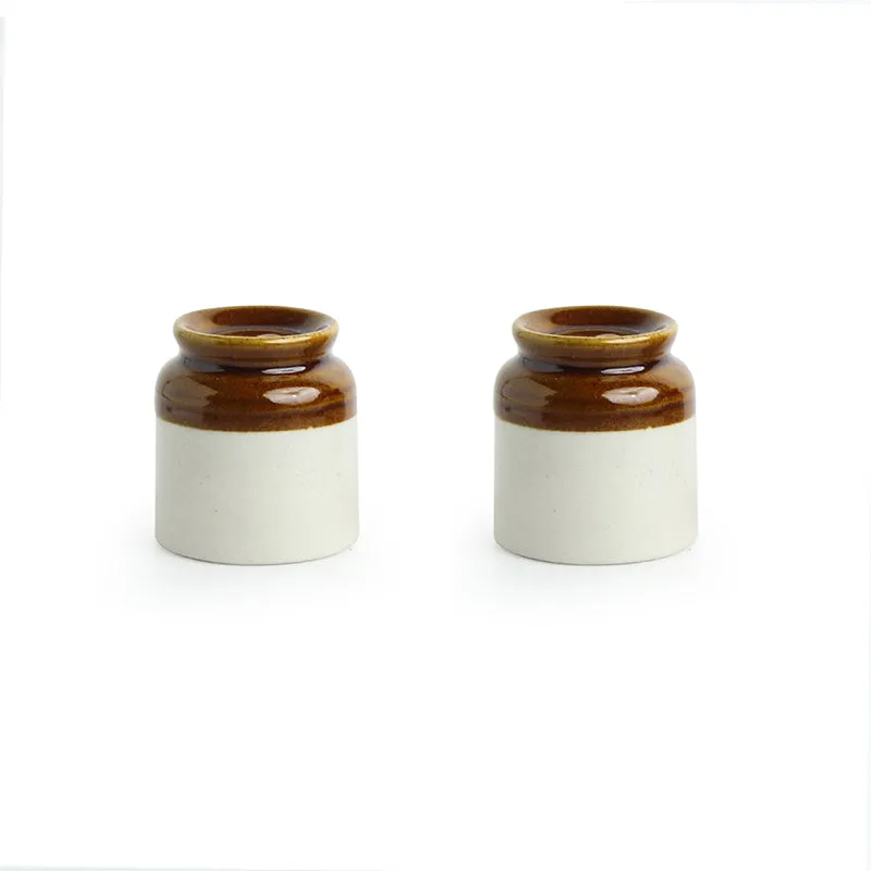 Two brown and white ceramic seasoning shakers shown side by side