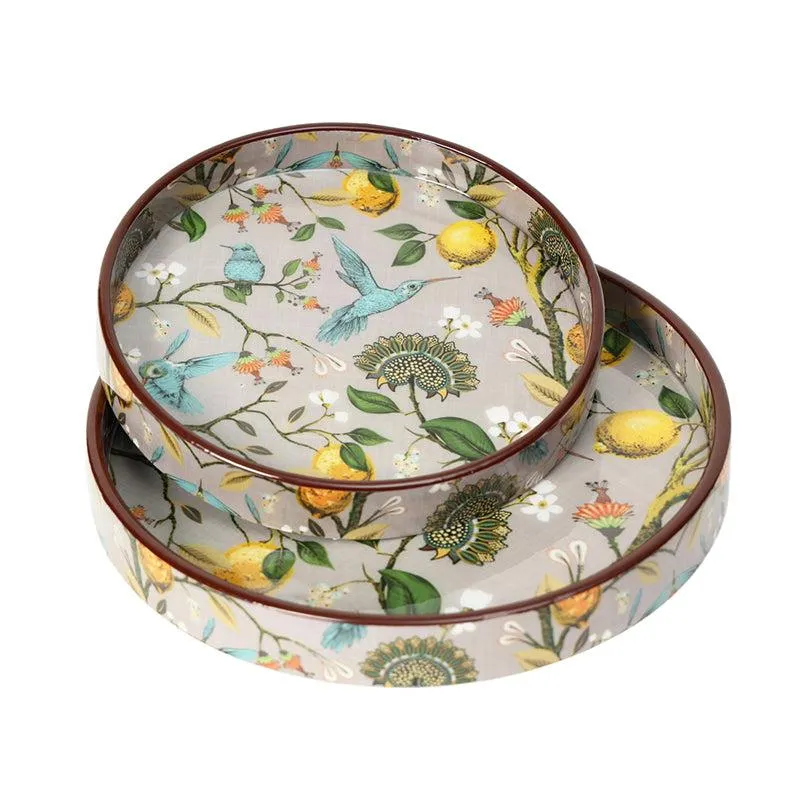 Two round trays stacked together, featuring colourful birds, lemons, flowers and leaves.