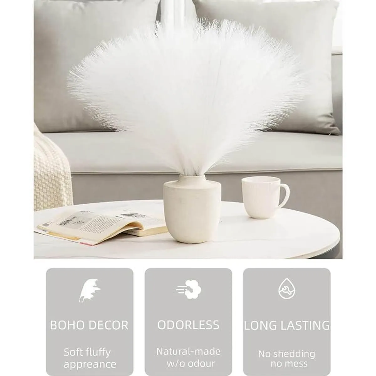 White faux pampas arrangement in a small vase on a coffee table